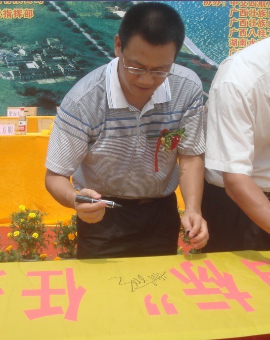 廣西新港灣公司副總經(jīng)理姚方明在“奮戰100天，如期實(shí)現魚(yú)梁工程截流、通航、發(fā)電‘三大目標’”橫幅上簽字